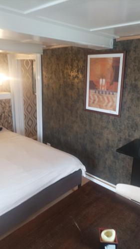 a bedroom with a bed and a picture on the wall at Maison trois chambres in Schwändi