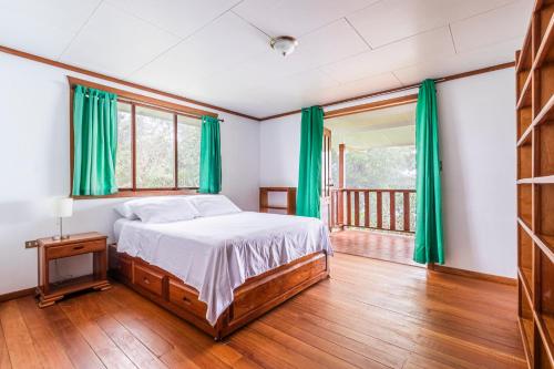 sypialnia z łóżkiem i zielonymi zasłonami w obiekcie Refugio San Antonio - 1500 acre Private Preserve w mieście Guaria