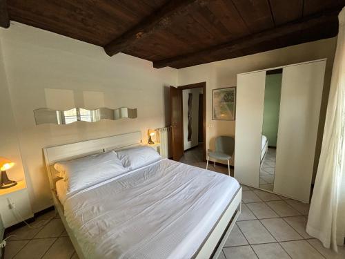 - une chambre avec un grand lit blanc dans l'établissement -Ortaflats- Appartamento l'Isola, à Orta San Giulio