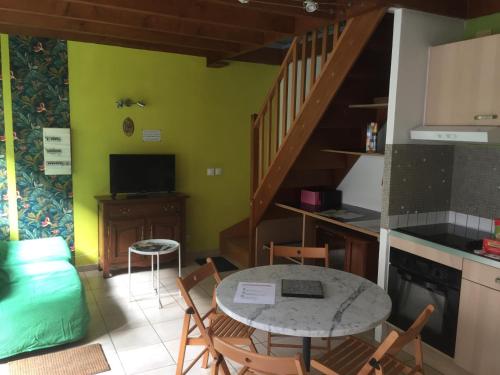 una cucina e una sala da pranzo con tavolo e sedie di La maisonnette a Les Andelys