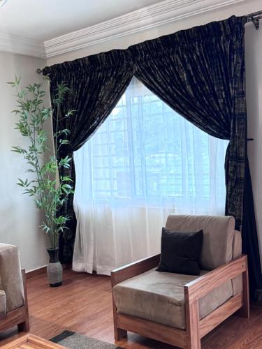 a living room with a couch and a large window at Akhard Haus in Buea
