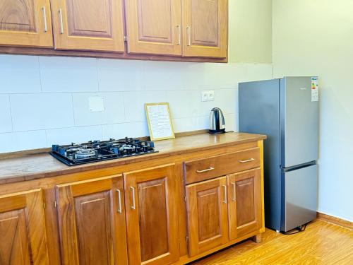 a kitchen with wooden cabinets and a stainless steel refrigerator at Akhard Haus in Buea