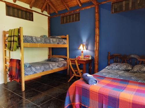 a bedroom with two bunk beds and a table with a lamp at Montañita Cabañas in Montañita