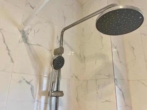 a shower with a shower head in a bathroom at Akhard Haus in Buea