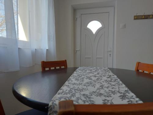 a dining room with a table and a door at Potyka Apartman in Tiszafüred