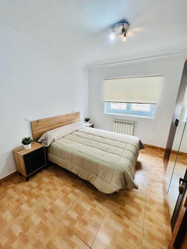 um quarto com uma cama grande e uma janela em Apartamento en Santander em Santander