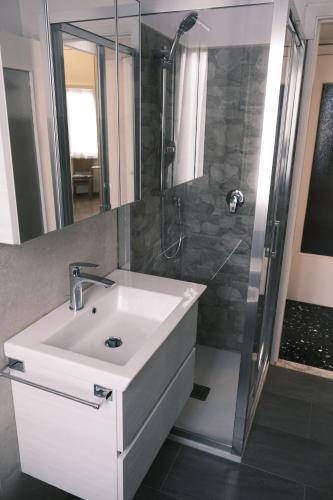 a bathroom with a white sink and a shower at La Casa di Giulia by PortofinoVacanze in Rapallo