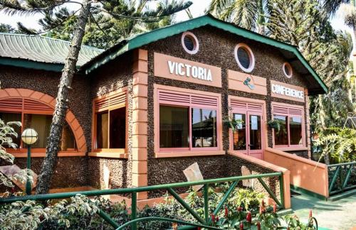 a building with a sign on the side of it at Country Lake Resort Garuga in Wakiso