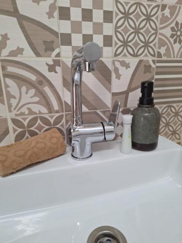 a bathroom sink with a faucet on a sink at Várfal apartman II in Eger