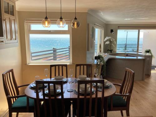 a dining room with a table and chairs and a kitchen at Sandpipers - Pet friendly in Ventnor