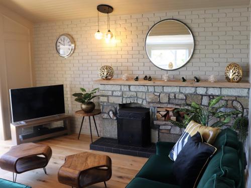 a living room with a fireplace and a mirror at Sandpipers in Ventnor