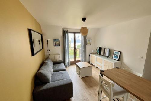un salon avec un canapé et une table dans l'établissement Renovated apartment - near the beach, à Ouistreham