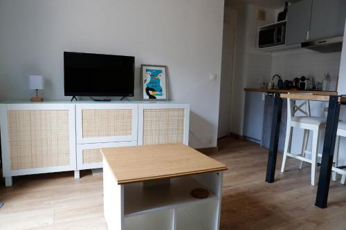 un salon avec une télévision à écran plat sur un comptoir dans l'établissement Renovated apartment - near the beach, à Ouistreham