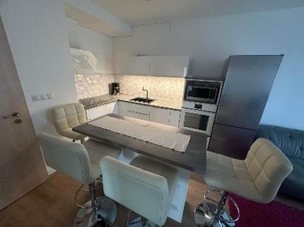 a kitchen with a table and some chairs and a kitchen at DunaVera Apartman in Budapest