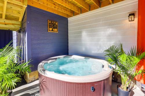 a hot tub on a patio with plants at Chic Spacious AVL Oasis with Hot Tub and Fire Pit in Asheville