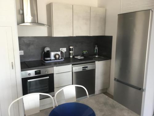 une petite cuisine avec un évier et un réfrigérateur dans l'établissement EDEN ROC, à Canet