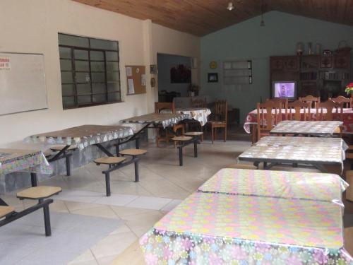 ein Klassenzimmer mit Tischen und Bänken in einem Raum in der Unterkunft Sítio Colina das Flores. Lugar Encantador com Piscina para Grupos in Franco da Rocha