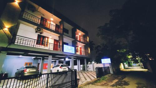 a white car parked in front of a building at night at Tulip Homes by The Oaks Inn in Cochin