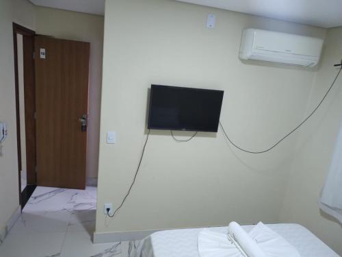 a room with a tv on a wall with a bed at LONDRES HOTEL in Gama