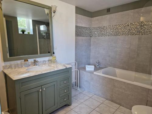 La salle de bains est pourvue d'une baignoire, d'un lavabo et d'une baignoire. dans l'établissement La cour, à Honfleur