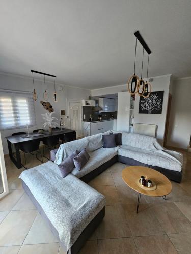 sala de estar con sofá, mesa y cocina en Villa Theo Corfu, en Ágios Ioánnis