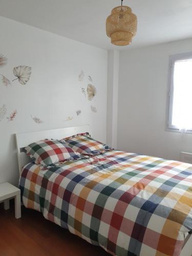 um quarto com uma cama com um cobertor xadrez em Chez Thai et Isabelle em Oissery