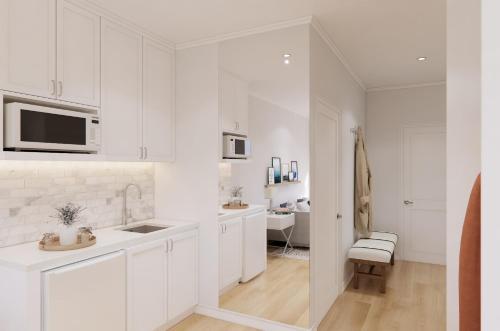 a white kitchen with white cabinets and a sink at Dexter Suite in Elk Rapids