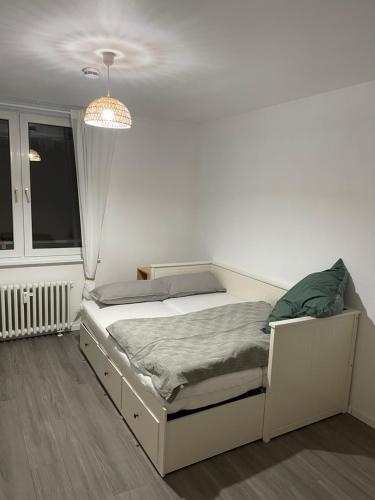 a white bedroom with a bed and a window at Little Royal in Garbsen