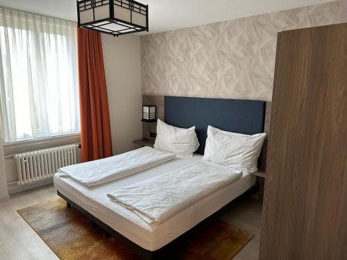 a bedroom with a large bed with white sheets at Hotel Spatz in Luzern