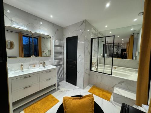 baño con 2 lavabos y espejo grande en La plaine de l'Angelus en Chailly-en-Bière