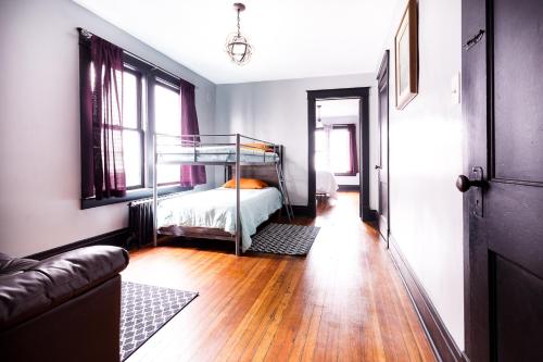Schlafzimmer mit Etagenbett und Holzboden in der Unterkunft The Pub- 8BR Free Parking, Minutes From Falls & Casino in Niagara Falls