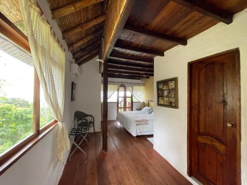 a bedroom with a bed and a large window at Samai Lodge Holistic Living in Olón