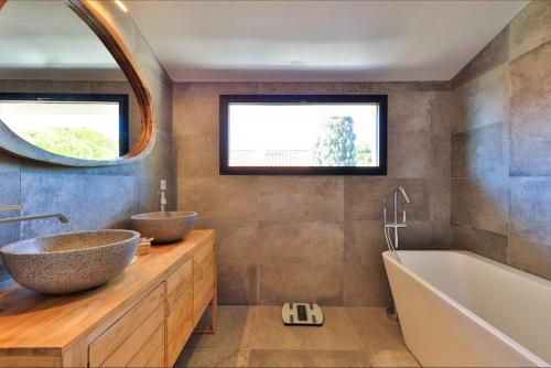 une salle de bain avec deux lavabos, une baignoire et un miroir dans l'établissement Luxueuse villa avec piscine et vue panoramique - Villa Perry, à Saint-Cyr-sur-Mer
