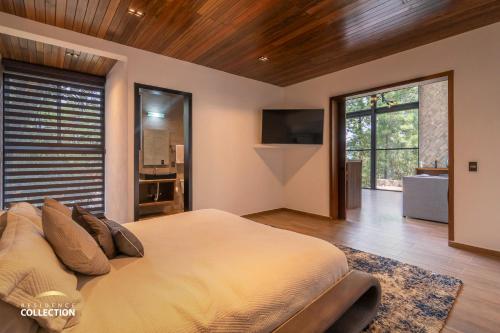 Un dormitorio con una cama grande y una ventana grande. en Cabaña de lujo en La Toscana Mazamitla 1, en Mazamitla