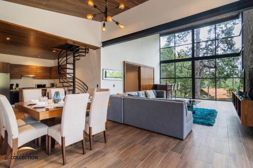 comedor y sala de estar con sofá y mesa en Cabaña de lujo en La Toscana Mazamitla 1, en Mazamitla