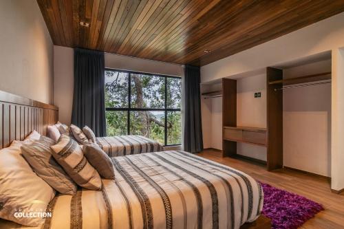 1 dormitorio con cama grande y ventana grande en Cabaña de lujo en La Toscana Mazamitla 1, en Mazamitla