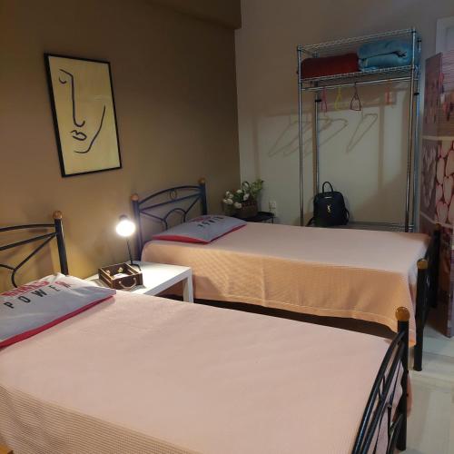 a bedroom with two beds and a table with a lamp at Family Apartment in Patra