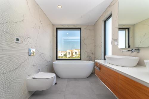 ein Badezimmer mit einer Badewanne, einem WC und einem Waschbecken in der Unterkunft Vivenda Boa Vida in Carvoeiro