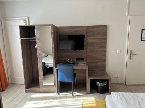 a small room with a desk and a television at Hotel Spatz in Luzern