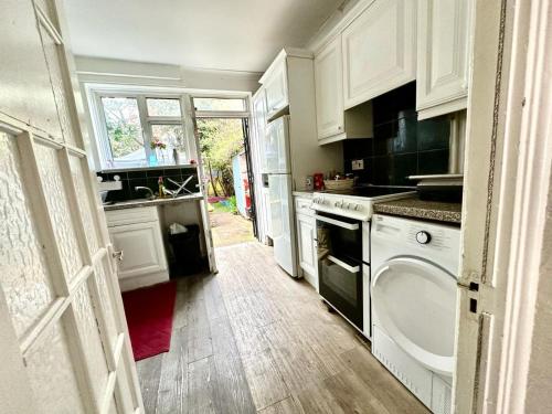 倫敦的住宿－Whitechapel Rooms R1，厨房配有白色橱柜和洗碗机。