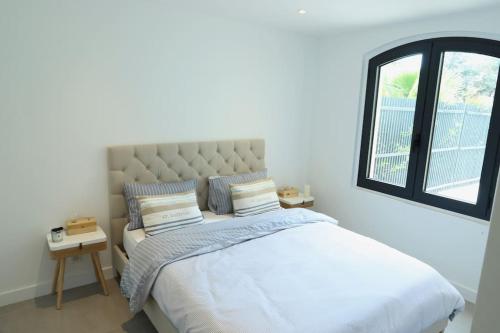 ein Schlafzimmer mit großem Bett und Fenster in der Unterkunft Grimaud Jardin Boreals 3 Bed Luxury Appt in Grimaud