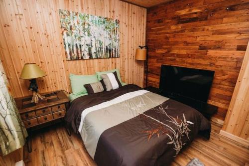 een slaapkamer met een bed in een blokhut bij Cozy Cabin in Pocono Farms with Hot tub Fire pit and close to many attractions in Pocono Country Place