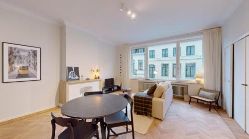 a living room with a table and a couch at Magnifique appartement - Quartier Louise! in Brussels