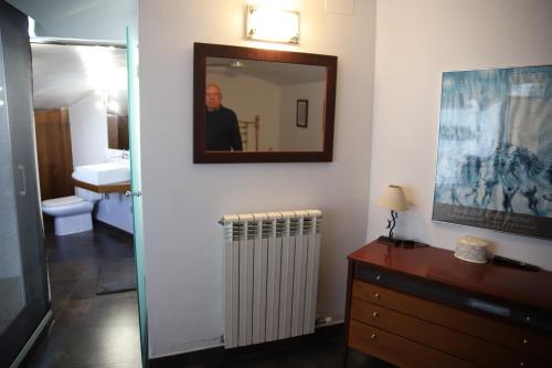 a man in a bathroom with a mirror and a radiator at ESLORA in Platja  d'Aro