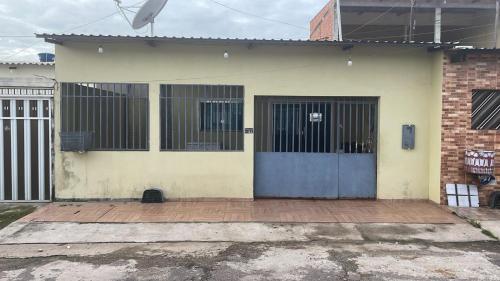 ein Haus mit einer blauen Tür mit Balken drauf in der Unterkunft Casa 2 Quartos Manaus in Manaus