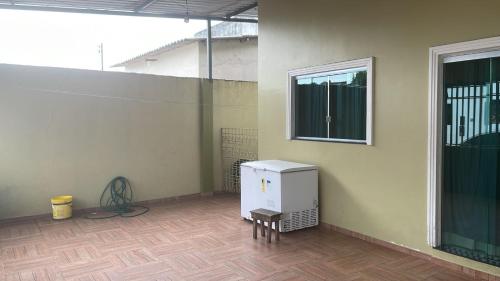 um frigorífico branco sentado num quarto com uma janela em Casa 2 Quartos Manaus em Manaus