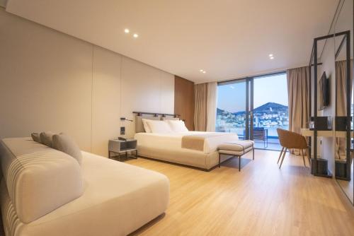 a hotel room with two beds and a balcony at ALYACHT Premium Hotel in Sarandë