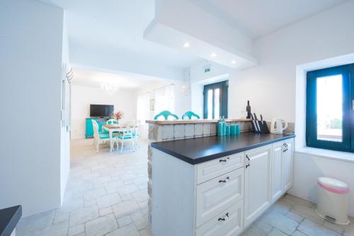 a kitchen with white cabinets and a black counter top at Villa Tereza with Private Pool Sea View in Mlini