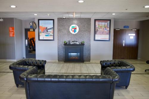 a waiting room with two chairs and a fireplace at Howard Johnson by Wyndham Lexington in Lexington