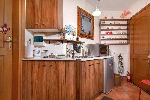 - une cuisine avec des placards en bois et un four micro-ondes dans l'établissement Ileana's house, à Vólos
